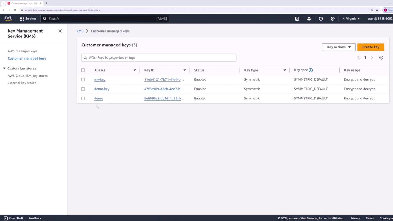 The image shows the AWS Key Management Service (KMS) console, displaying a list of customer-managed keys with details such as aliases, key IDs, status, key type, and usage.