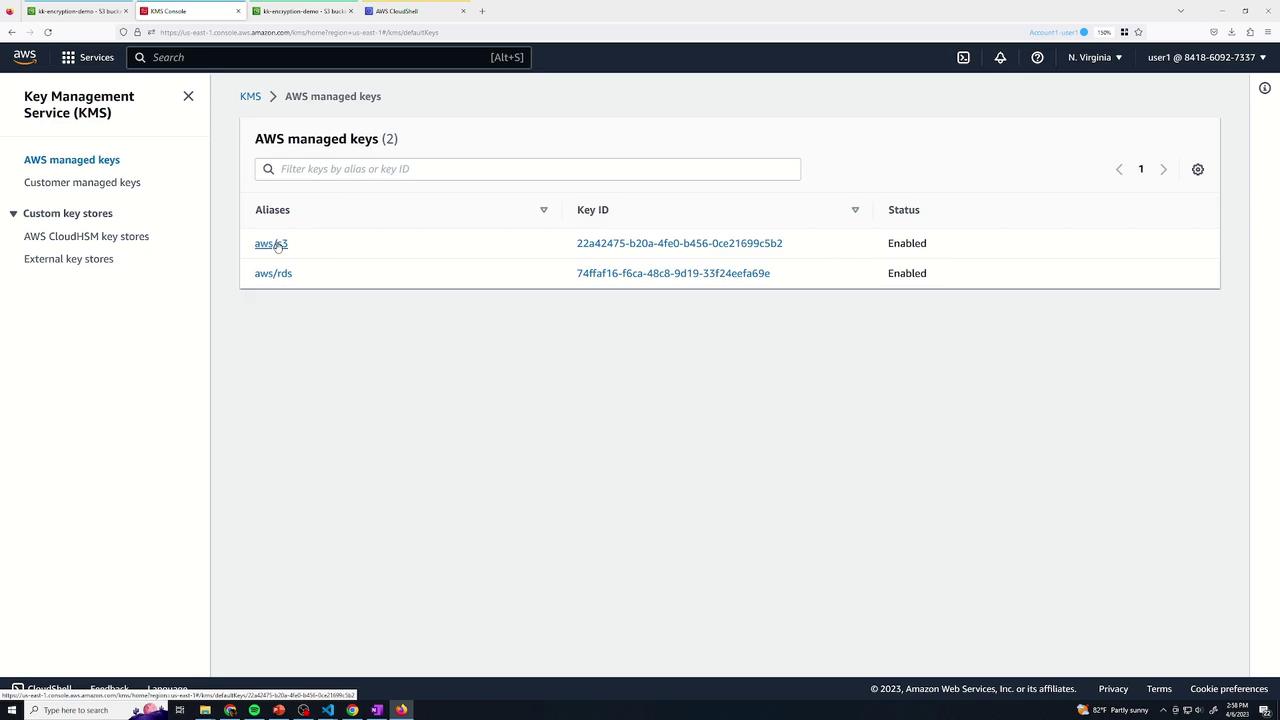 The image shows the AWS Key Management Service (KMS) console, displaying a list of AWS managed keys with their aliases, key IDs, and status. Two keys are listed, both with the status "Enabled."