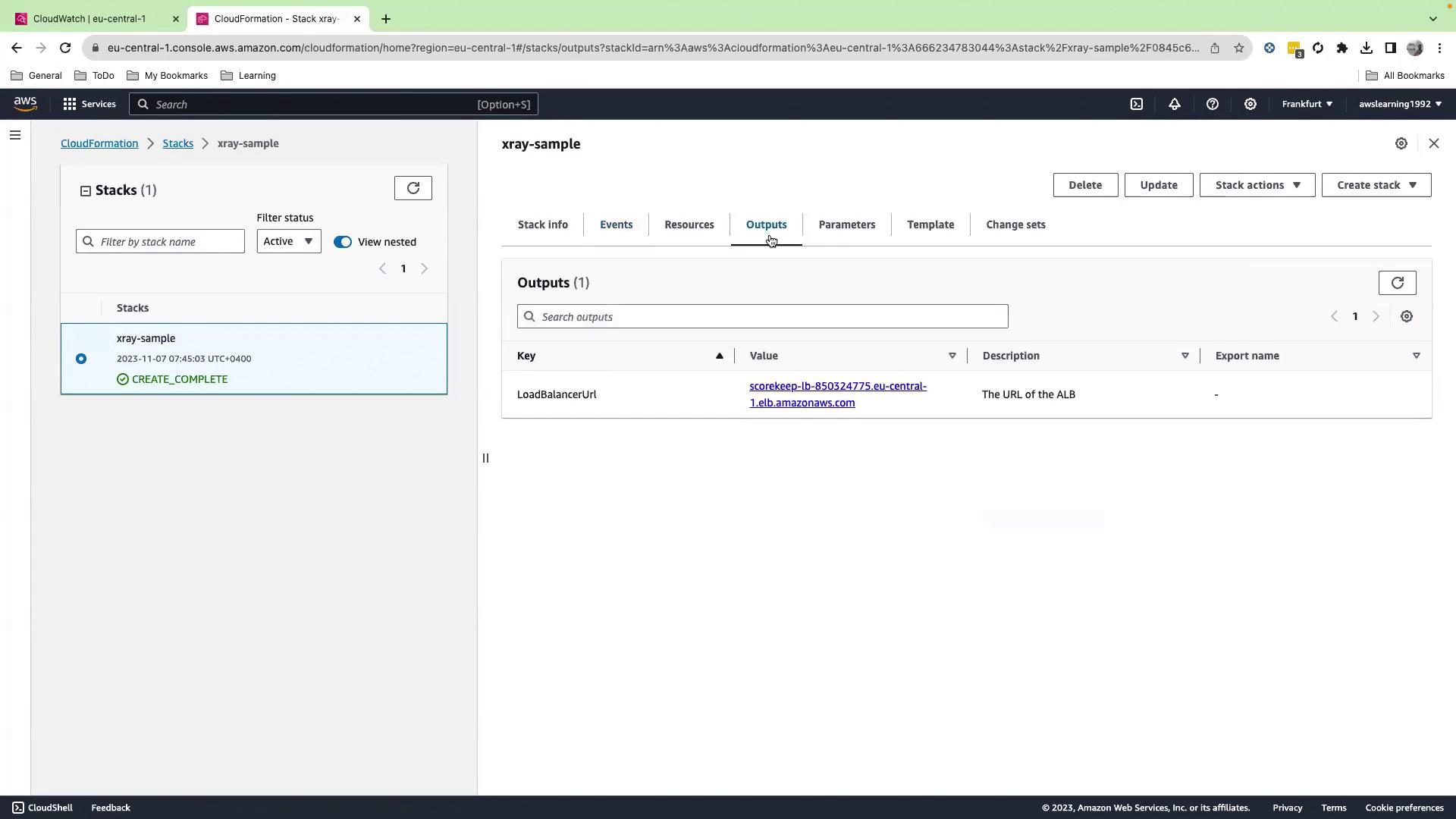 The image shows an AWS CloudFormation console with a stack named "xray-sample" that has a status of "CREATE_COMPLETE." The Outputs tab displays a LoadBalancerUrl with a specific URL value.