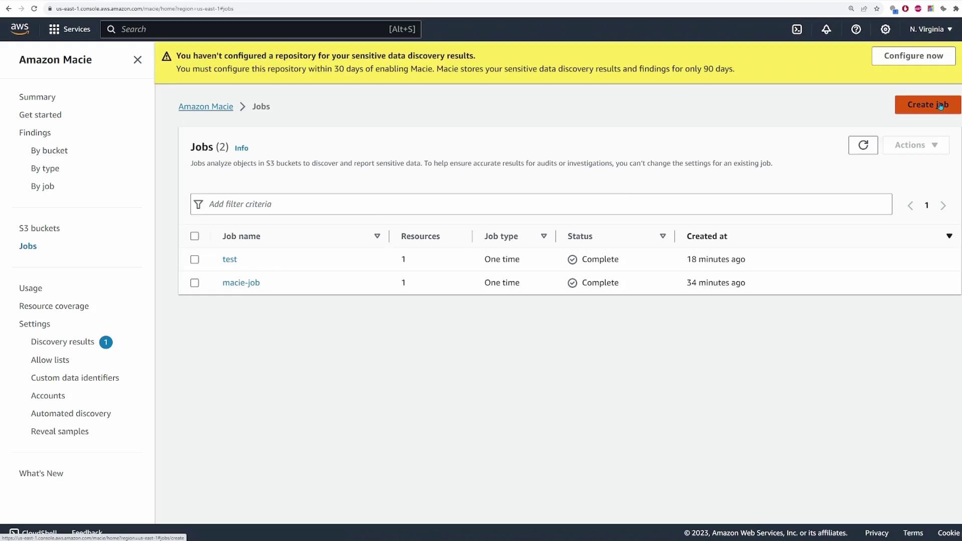 The image shows the Amazon Macie dashboard with a list of jobs, including their names, resources, job types, statuses, and creation times. A warning message at the top indicates that a repository for sensitive data discovery results needs to be configured.