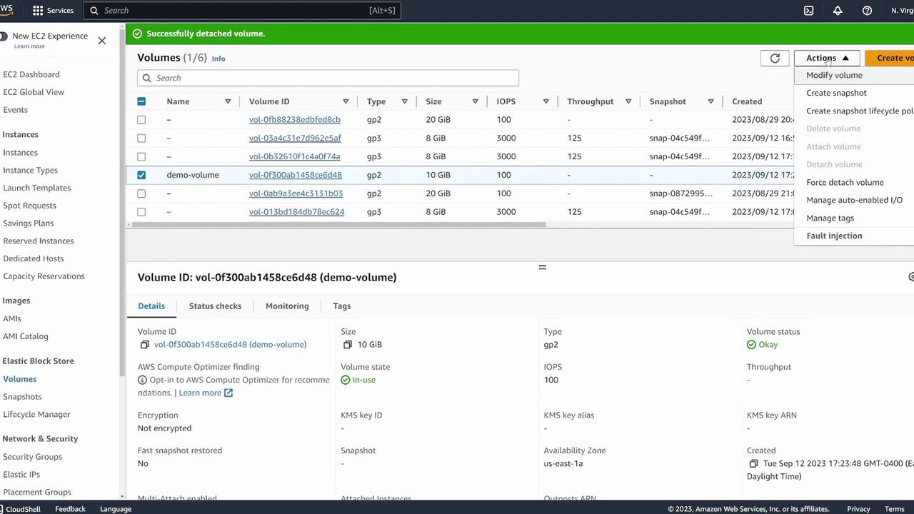 The image shows an AWS EC2 dashboard displaying a list of Elastic Block Store (EBS) volumes, with details about a selected volume named "demo-volume." Options for managing the volume are visible in a dropdown menu.