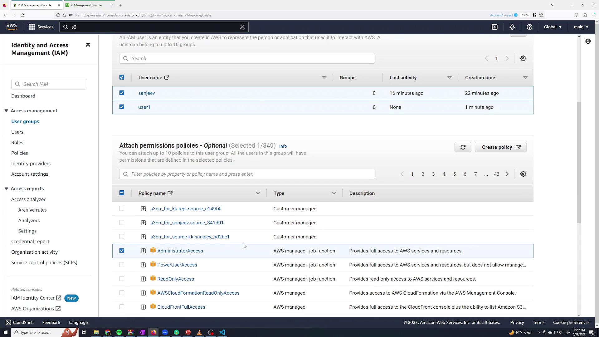 The image shows the AWS Identity and Access Management (IAM) console, displaying user groups and permission policies. Two users are listed, and various policies, including "AdministratorAccess," are shown for selection.