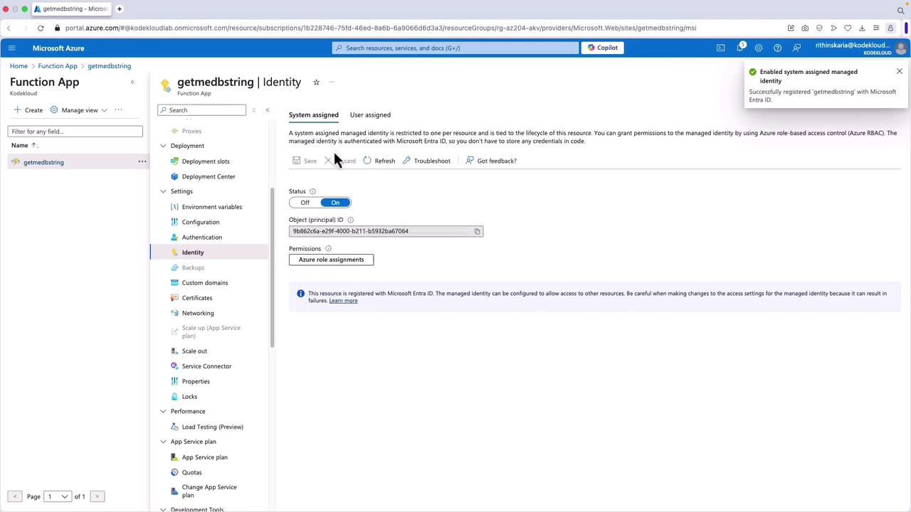 The image shows a Microsoft Azure portal interface for a Function App named "getmedbstring," specifically focusing on the Identity settings where a system-assigned managed identity is enabled.
