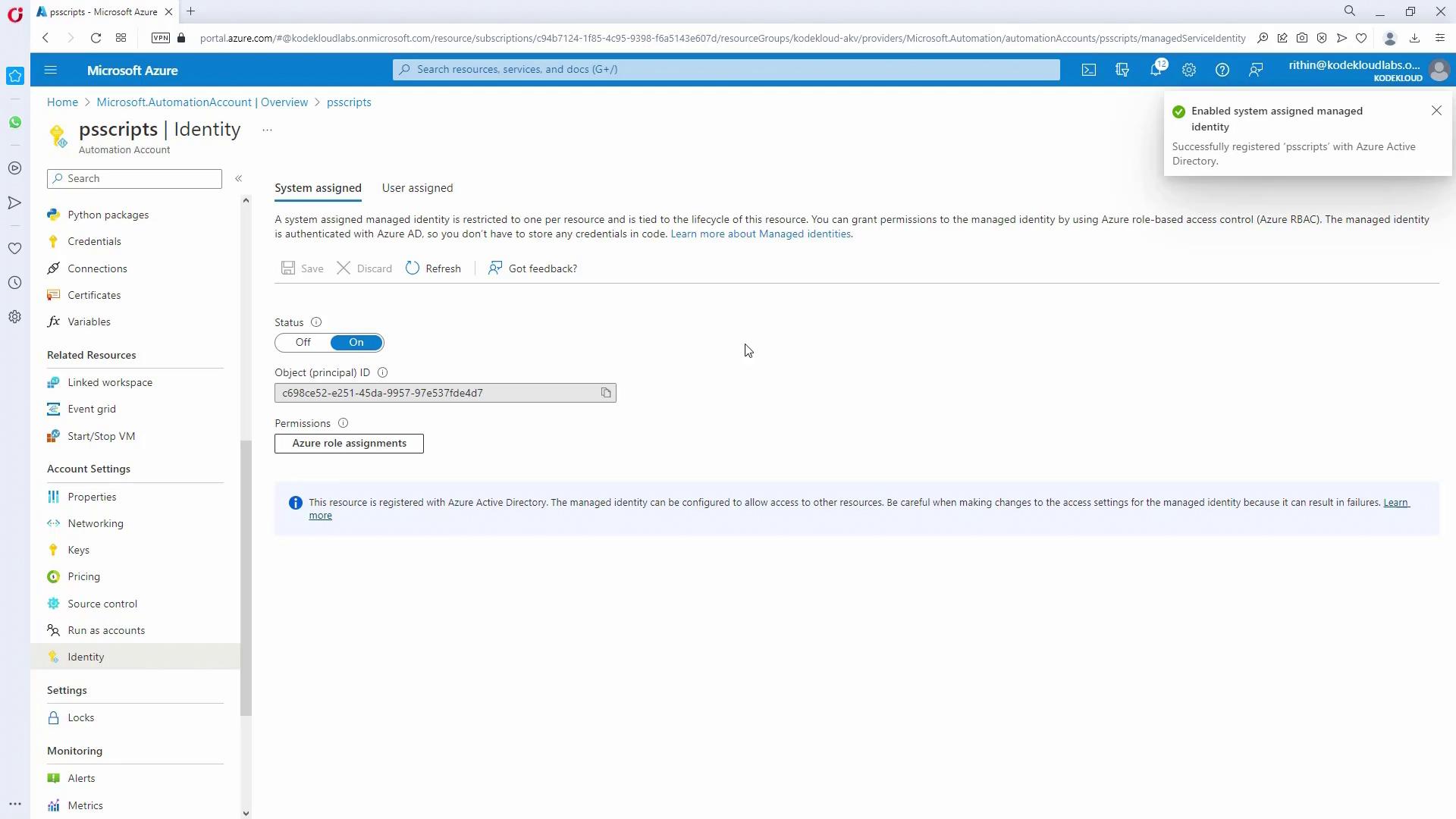 The image shows a Microsoft Azure portal page for managing a system-assigned managed identity within an automation account. The status is set to "On," and a notification confirms successful registration with Azure Active Directory.