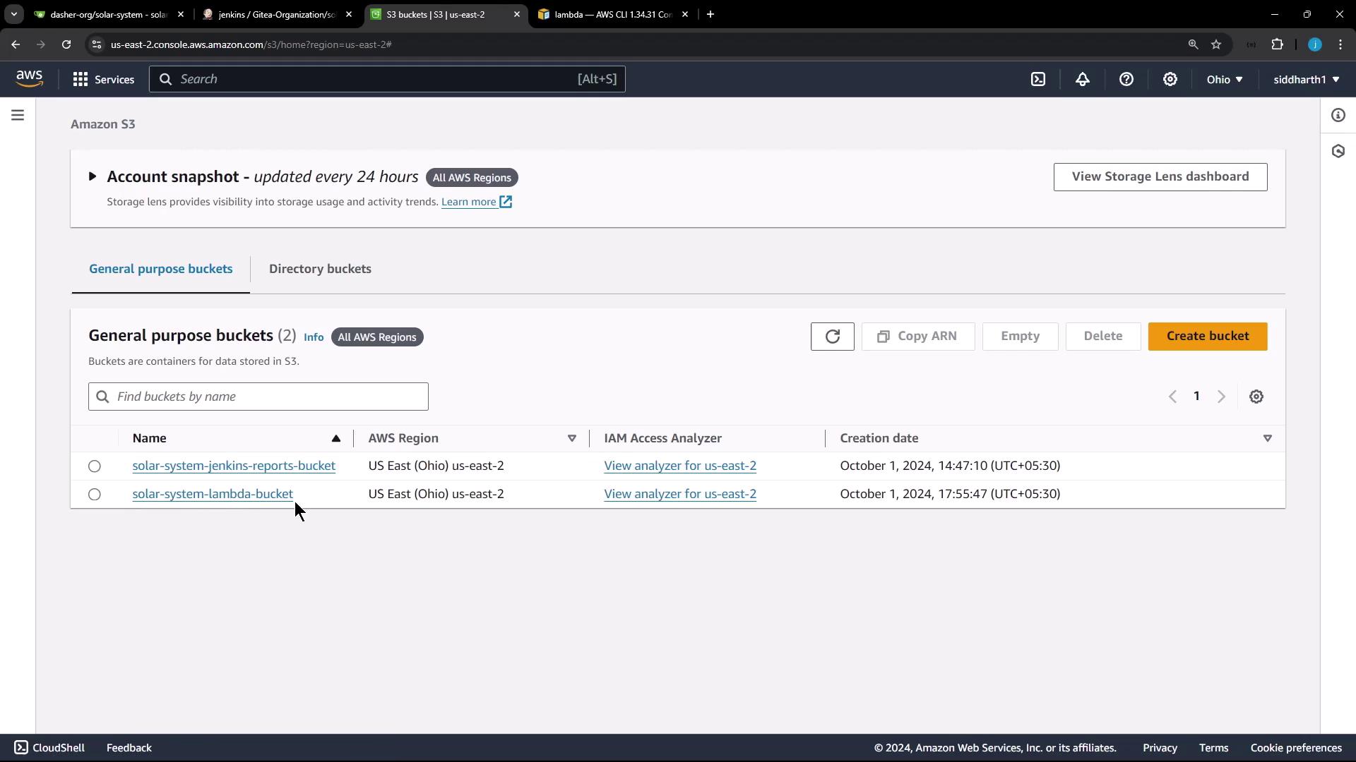 The image shows an Amazon S3 console with two general purpose buckets listed, named "solar-system-jenkins-reports-bucket" and "solar-system-lambda-bucket," both located in the US East (Ohio) region.