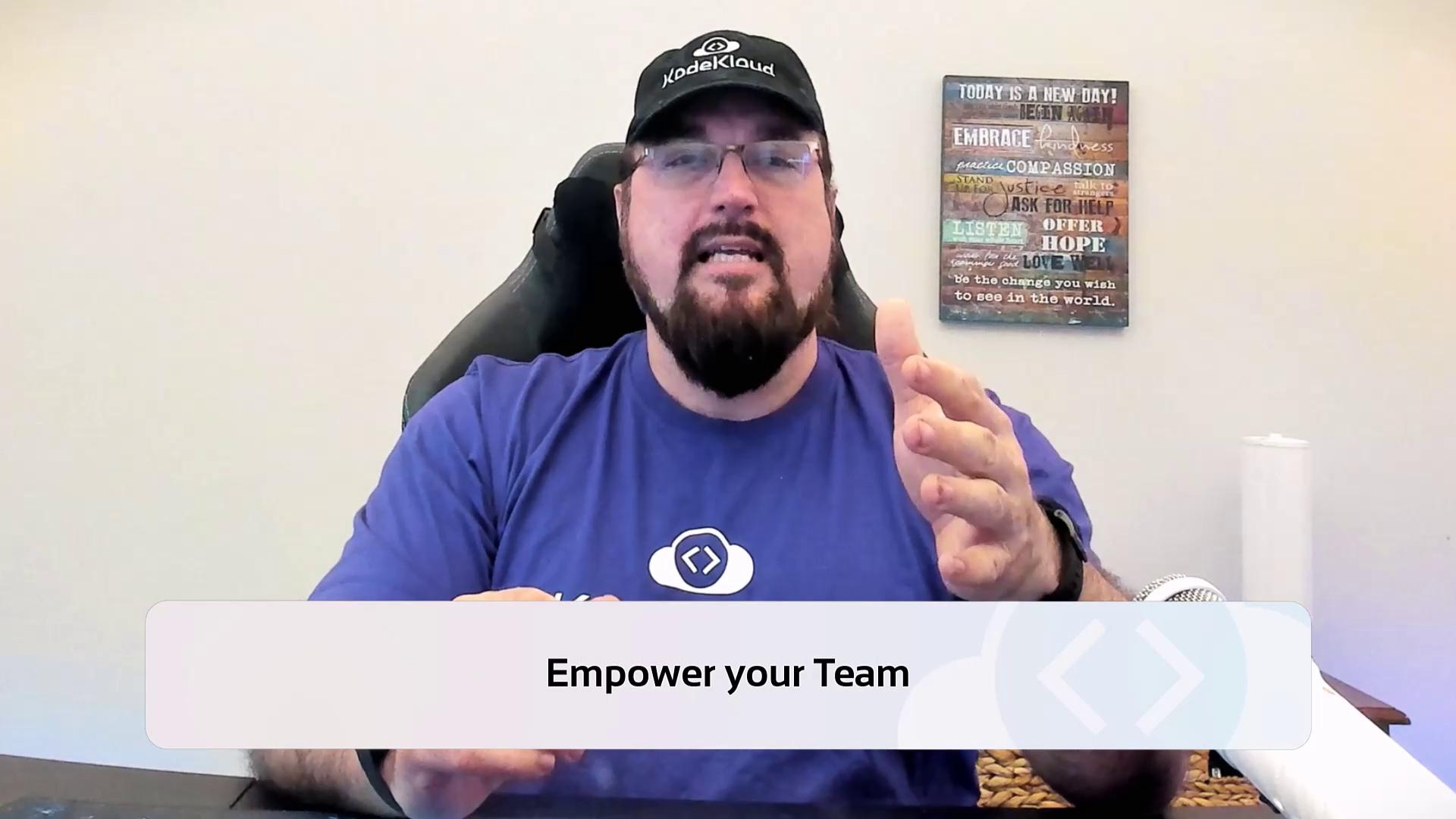 A person wearing a cap and a blue shirt is speaking, with a motivational sign on the wall behind them. The text overlay reads "Empower your Team."