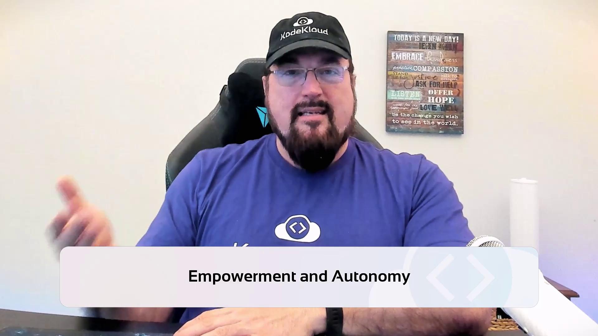 A person wearing a cap and glasses is sitting in front of a microphone, with a sign in the background and the text "Empowerment and Autonomy" displayed on the image.