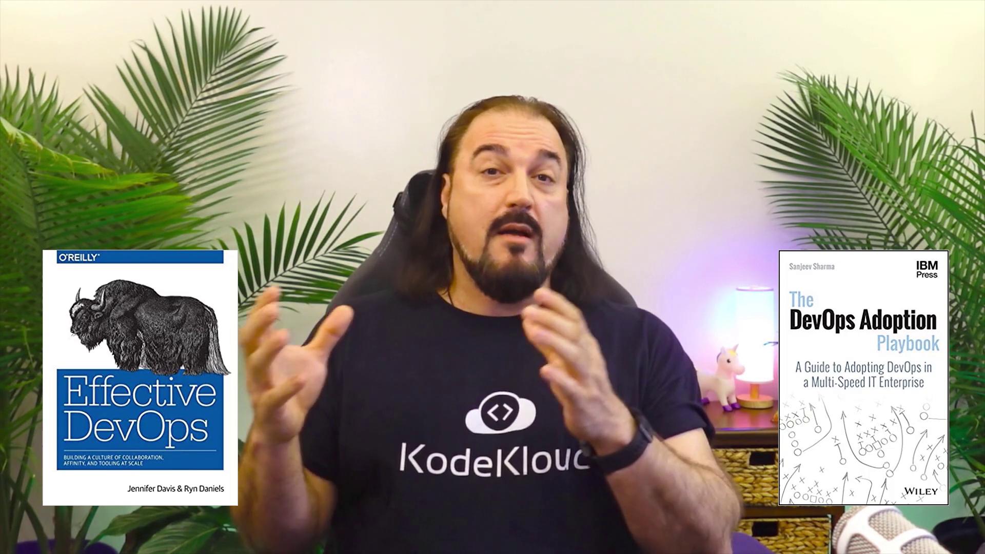 A person wearing a "KodeKloud" shirt is speaking, with two DevOps-related book covers displayed beside them, surrounded by green plants.