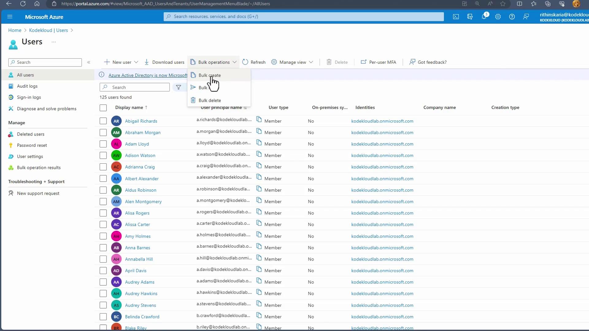 The image shows a Microsoft Azure portal interface displaying a list of users with details such as display names, user principal names, and user types. A dropdown menu for bulk operations is open, highlighting options like "Bulk create."